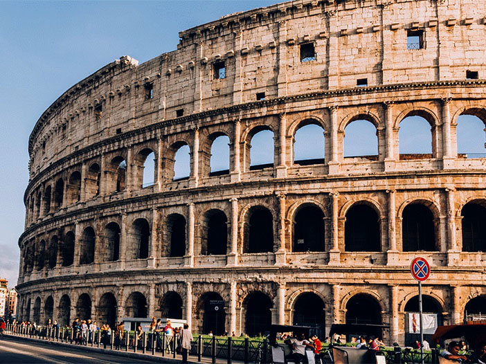 Coliseu romano. Prédio circular, amarelado com muitas janelas e pedaços faltando